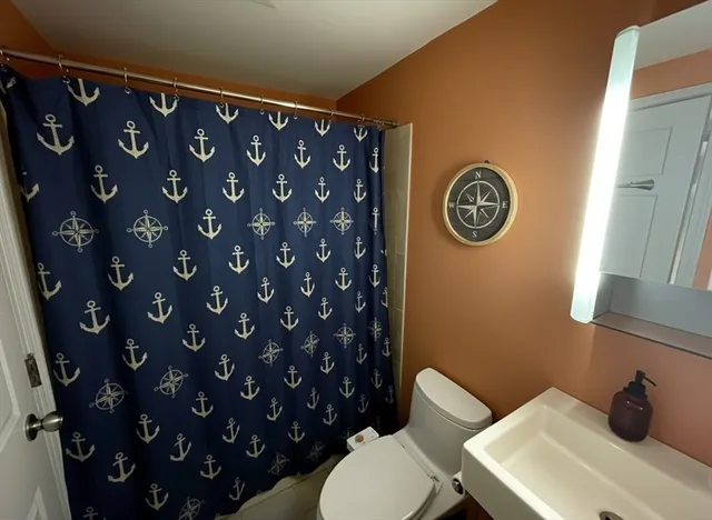 a bathroom with a toilet a sink and a mirror