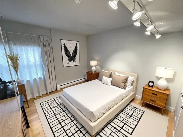 a bedroom with a large bed and a chandelier