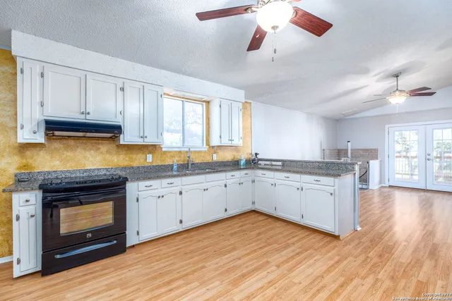 a kitchen with granite countertop white cabinets and stainless steel appliances