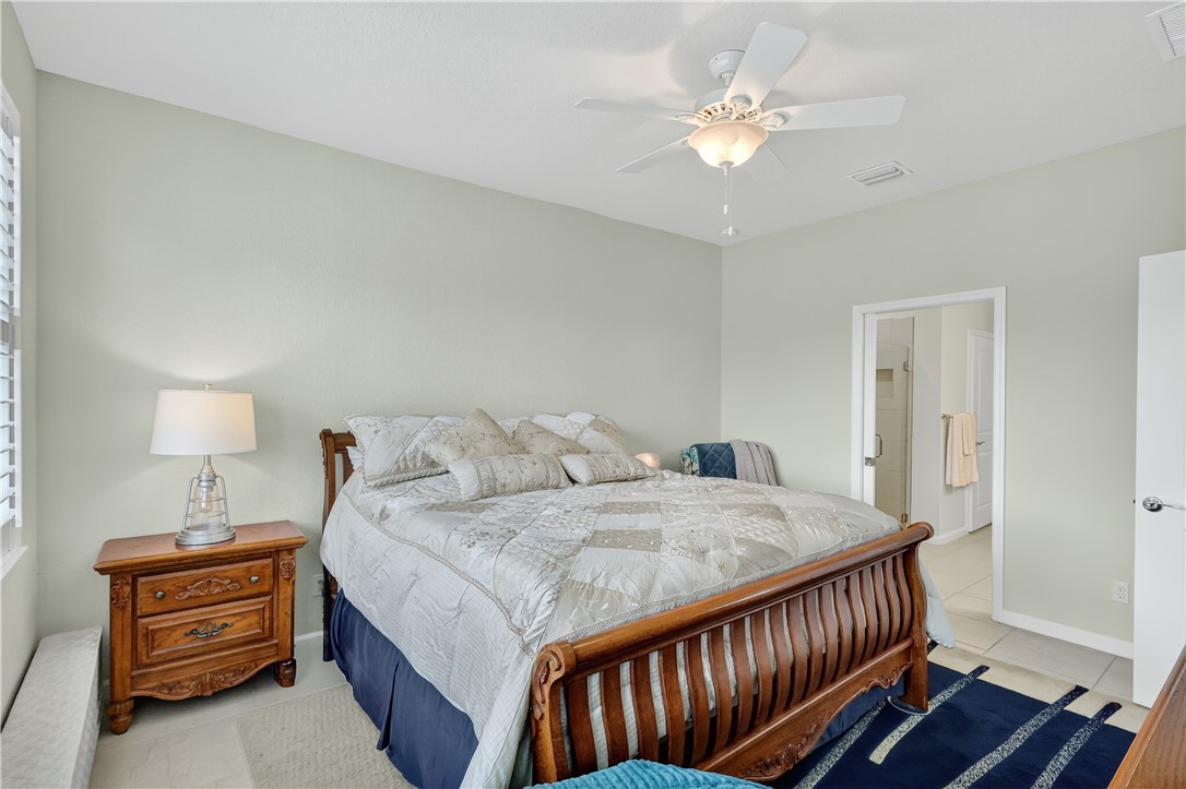 5130 Unity Square Vero Beach, FL 32967 - Photo 12 of 36 a bedroom with a bed and a chandelier