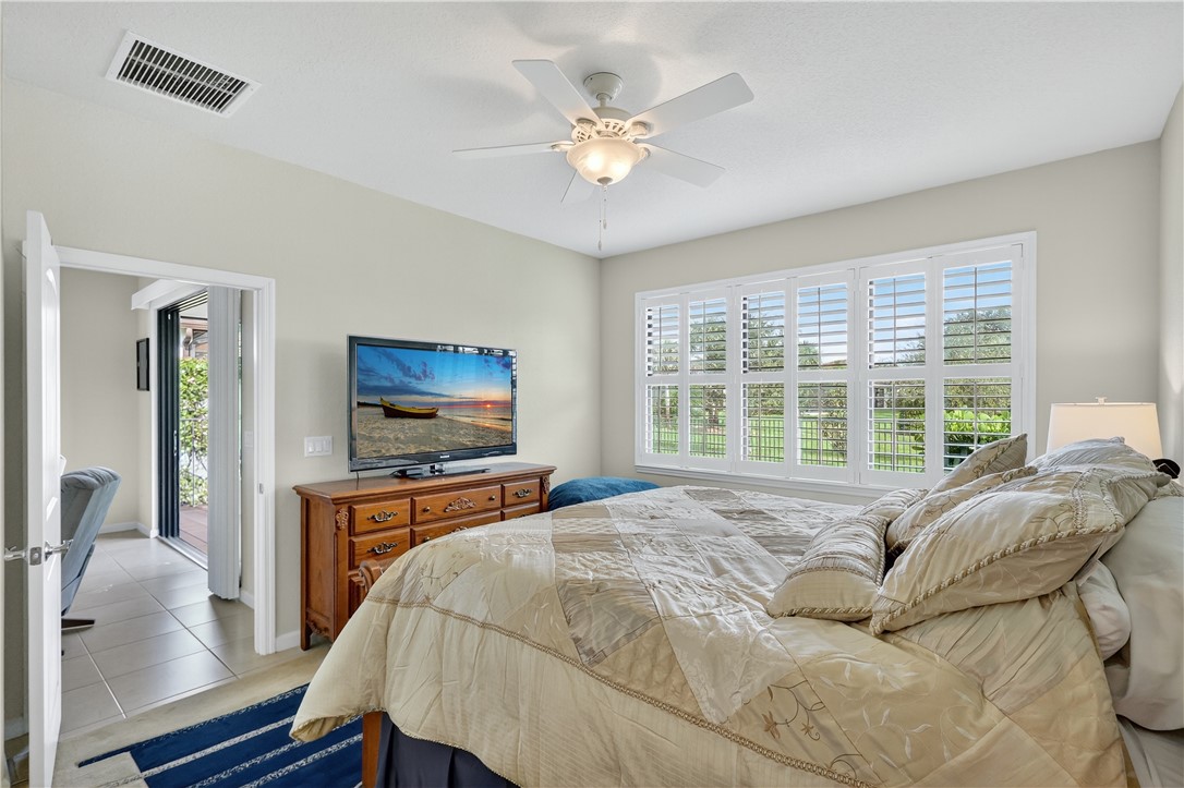 5130 Unity Square Vero Beach, FL 32967 - Photo 13 of 36 a bedroom with a bed and a flat screen tv