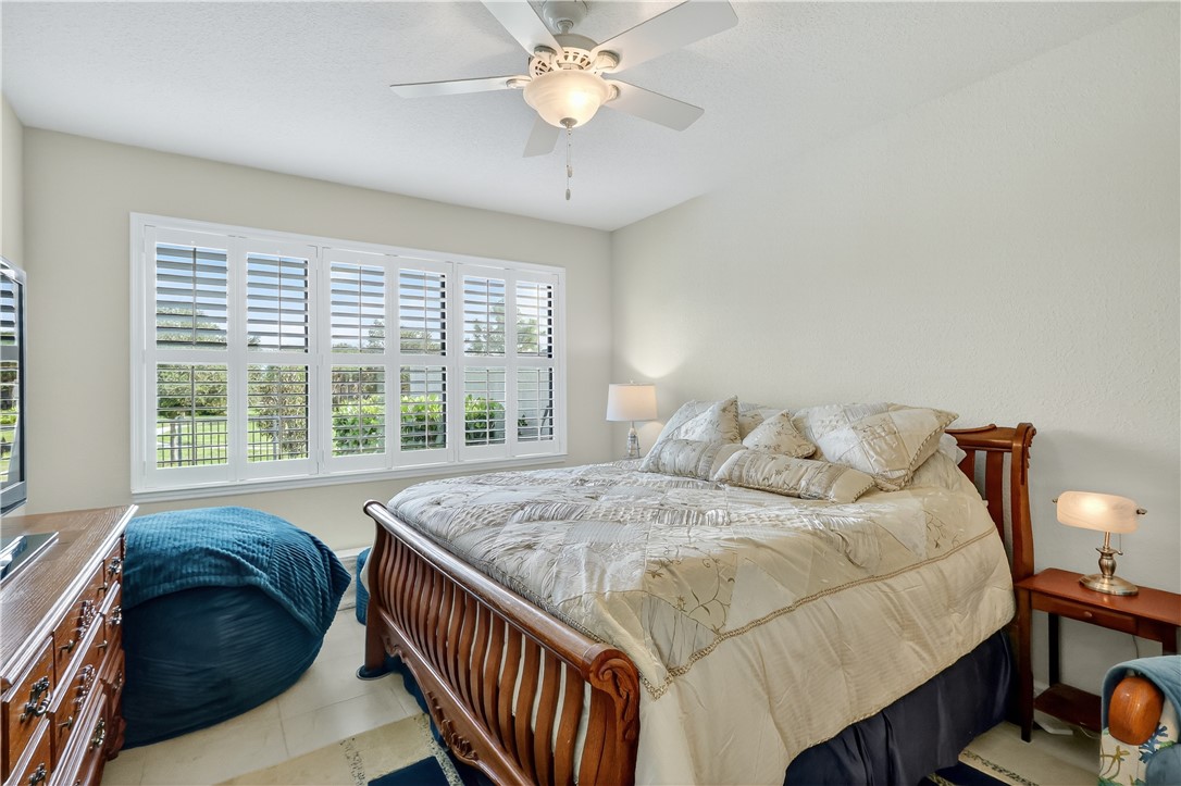 5130 Unity Square Vero Beach, FL 32967 - Photo 14 of 36 a bedroom with a bed and a chandelier