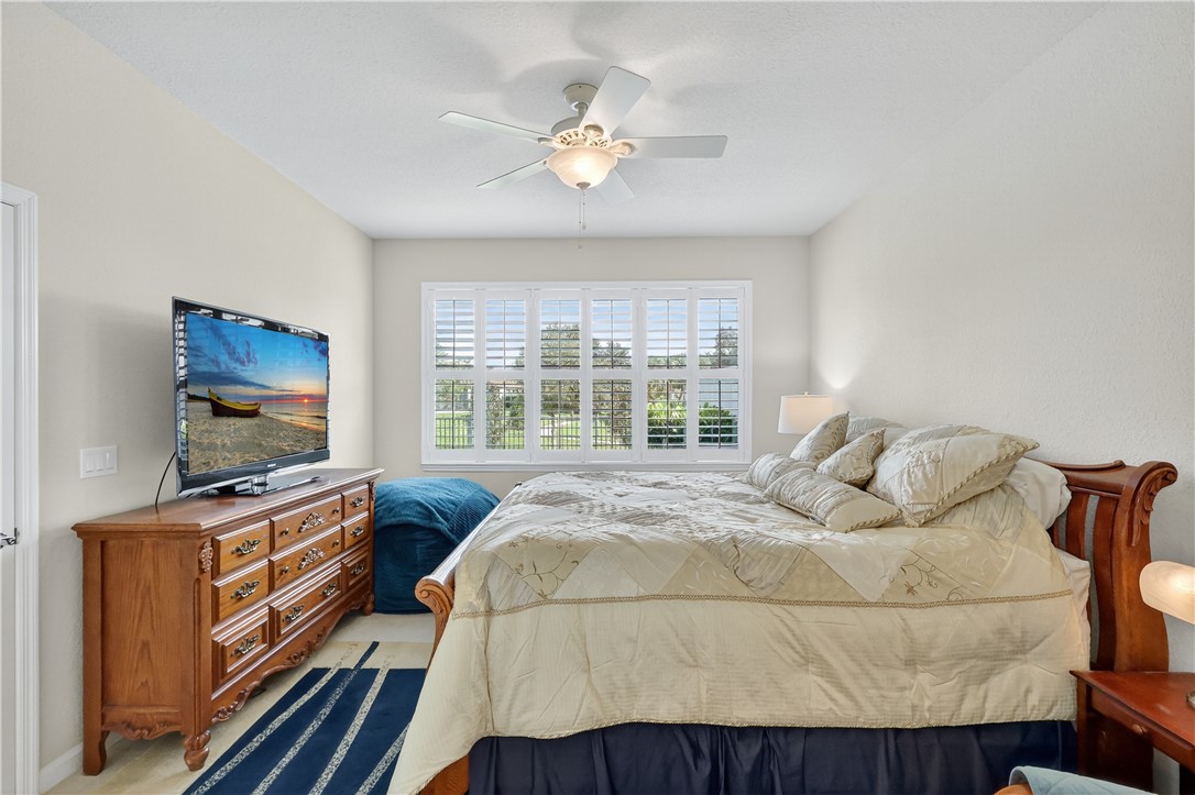 5130 Unity Square Vero Beach, FL 32967 - Photo 15 of 36 a bedroom with a bed and a flat screen tv