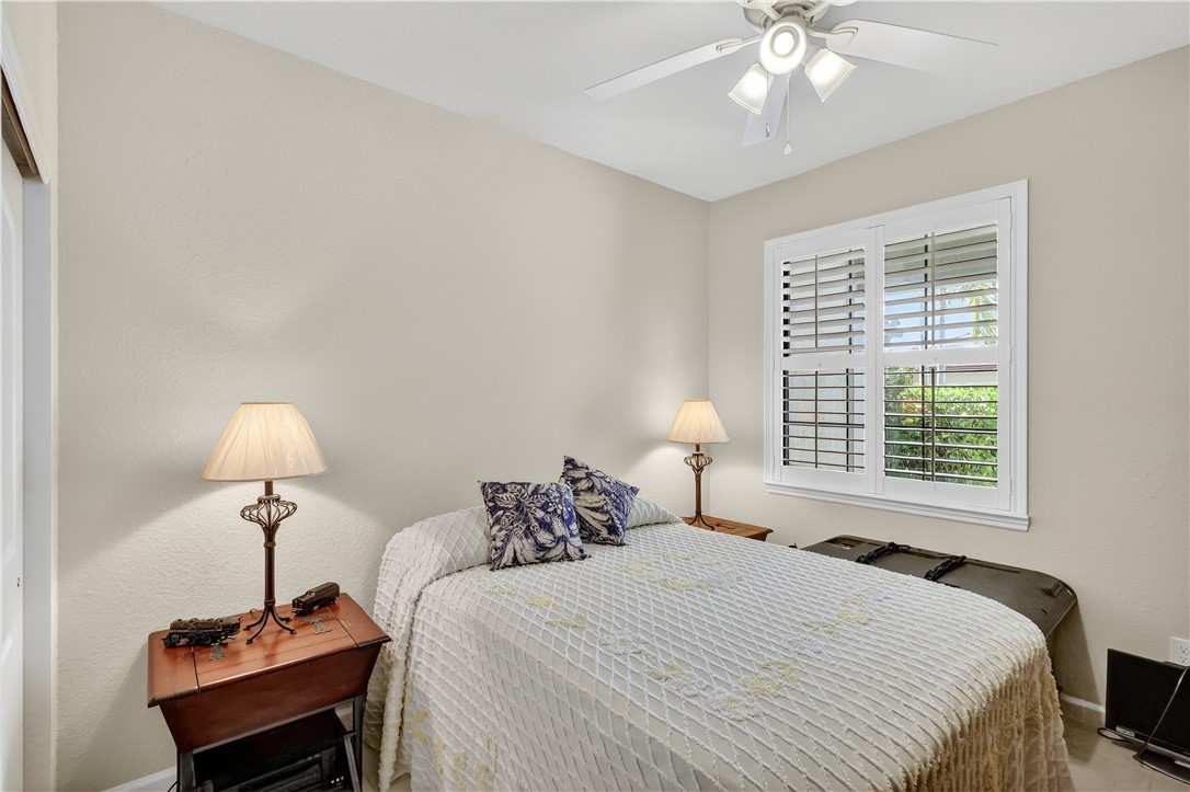 5130 Unity Square Vero Beach, FL 32967 - Photo 18 of 36 a bedroom with a bed and a lamp