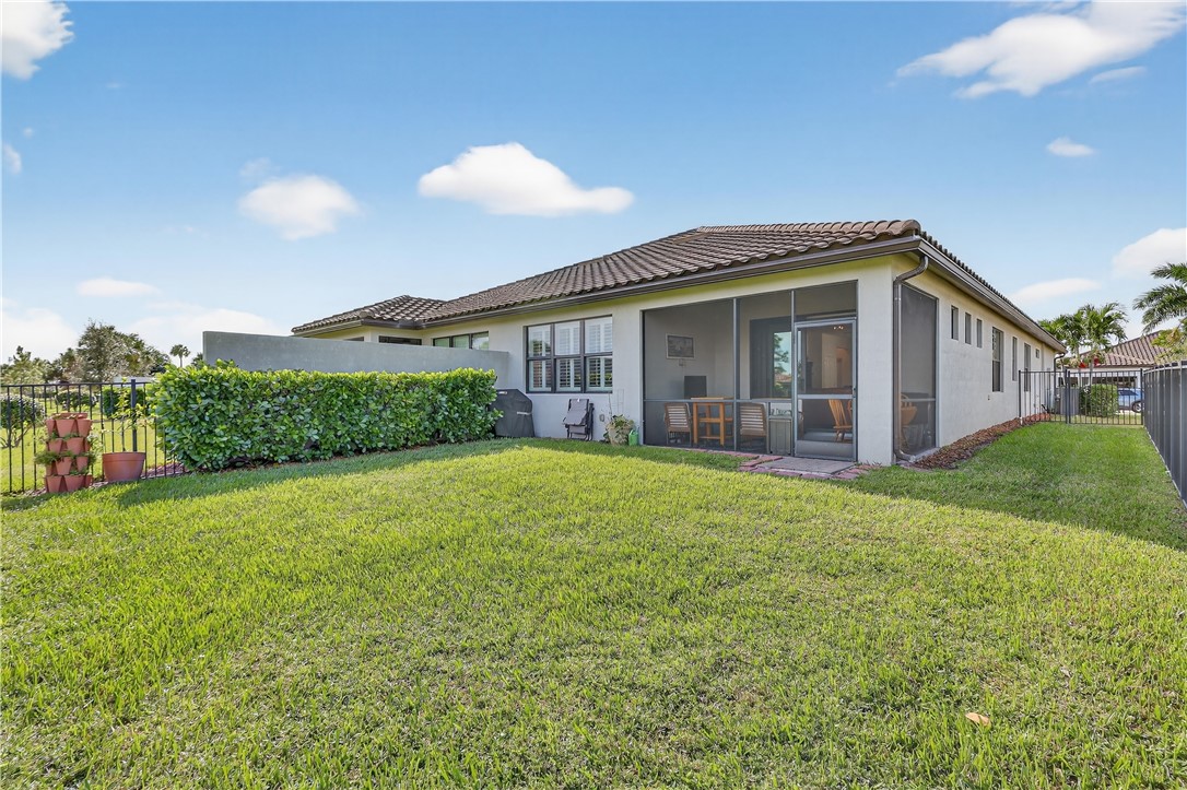 5130 Unity Square Vero Beach, FL 32967 - Photo 27 of 36 a front view of a house with a yard and potted plants