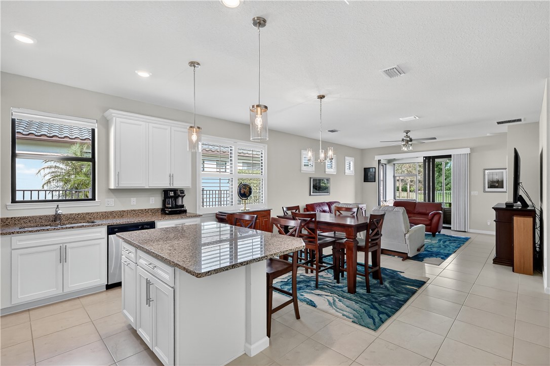 5130 Unity Square Vero Beach, FL 32967 - Photo 5 of 36 a kitchen with a stove a sink a counter top space and living room view