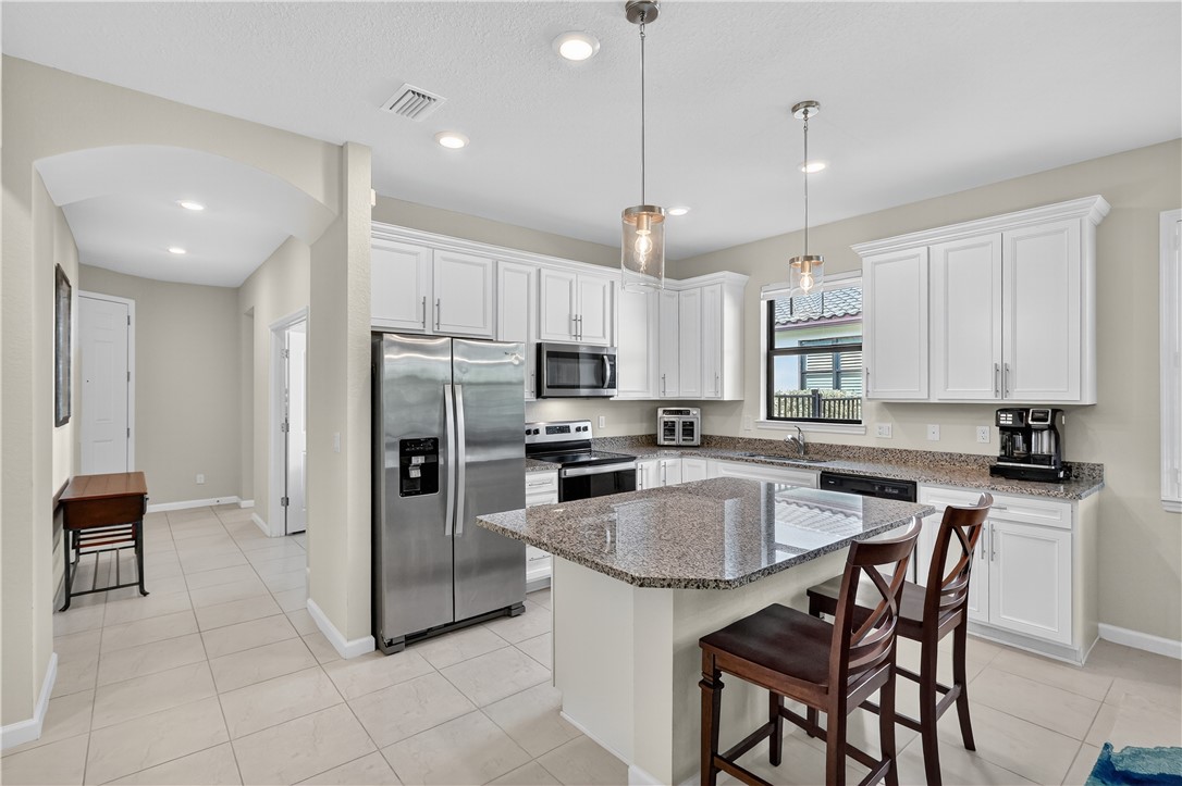5130 Unity Square Vero Beach, FL 32967 - Photo 10 of 36 a kitchen with kitchen island granite countertop a counter space cabinets stainless steel appliances and a center island