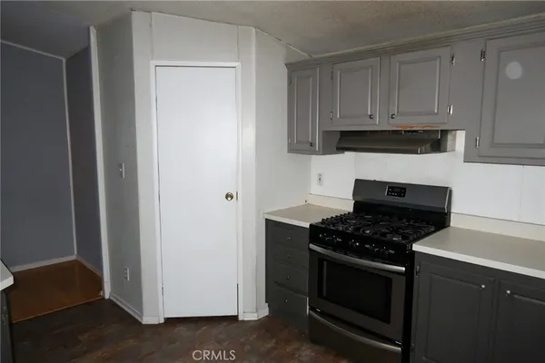 a kitchen with white cabinets and black appliances