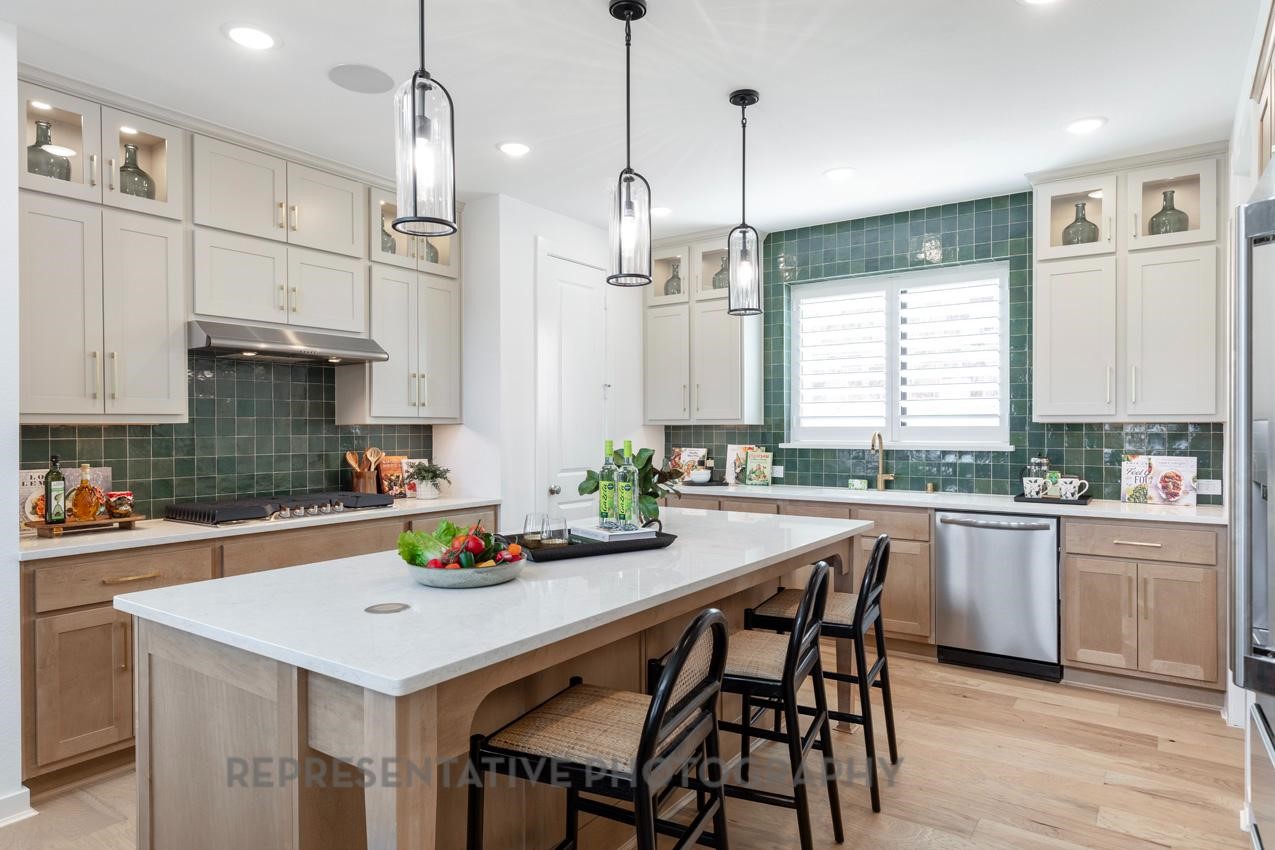 5327 Mango Blfs Street Manvel, TX 77578 - Photo 3 of 46 a kitchen with stainless steel appliances kitchen island granite countertop a sink a stove a dining table and chairs
