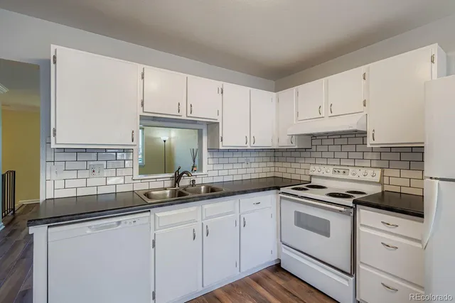 a kitchen with white cabinets and white appliances