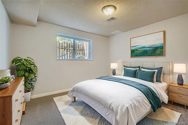 a bedroom with a bed and a painting on the wall