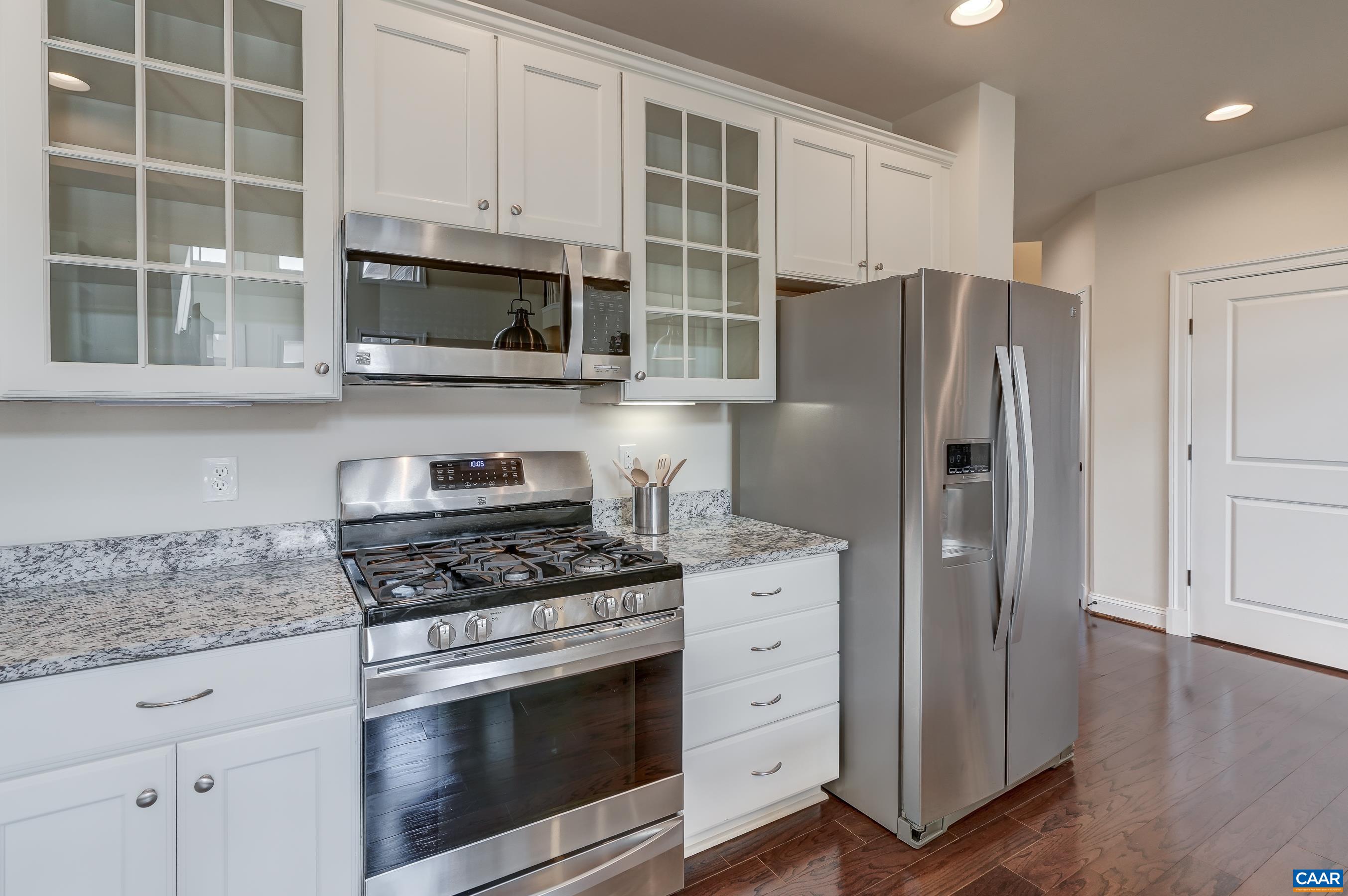 804 Golf View Drive Crozet, VA 22932 - Photo 11 of 62 a kitchen with stainless steel appliances white cabinets and a stove a refrigerator with wooden floor