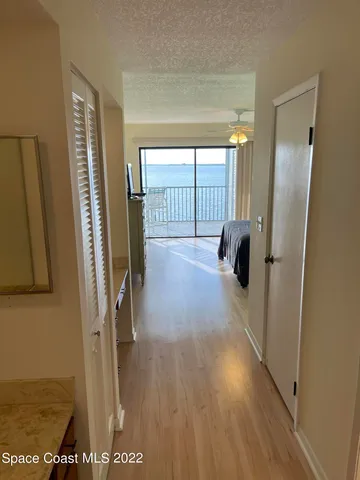 a view of hallway with stairs and wooden floor