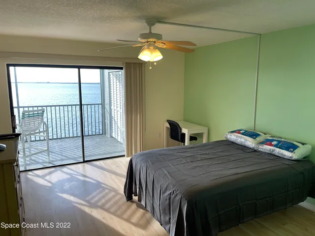 a bedroom with a bed and a large window