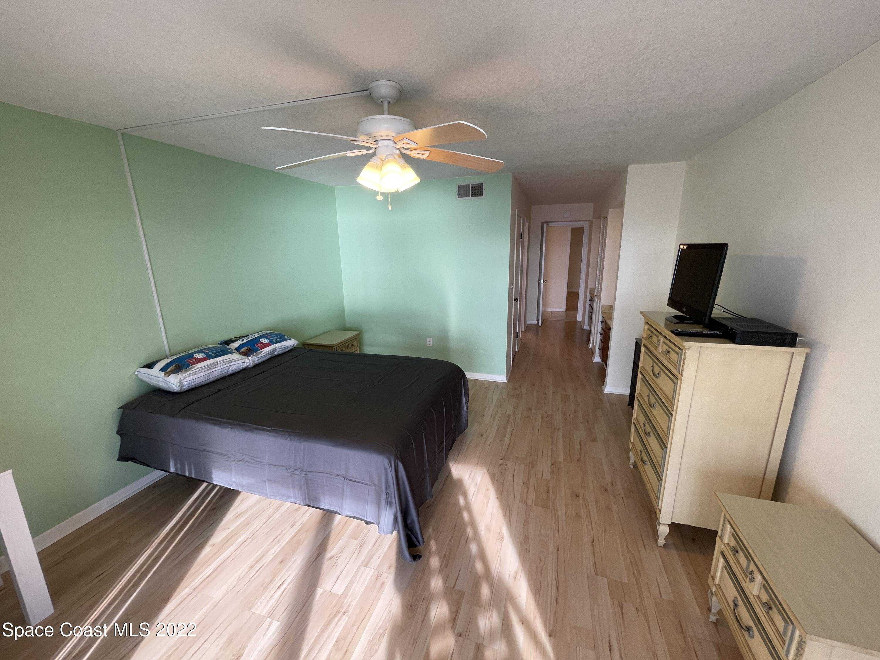 3799 South Banana River Boulevard, Unit 817 Cocoa Beach, FL 32931 - Photo 17 of 26 a bedroom with a bed and flat screen tv
