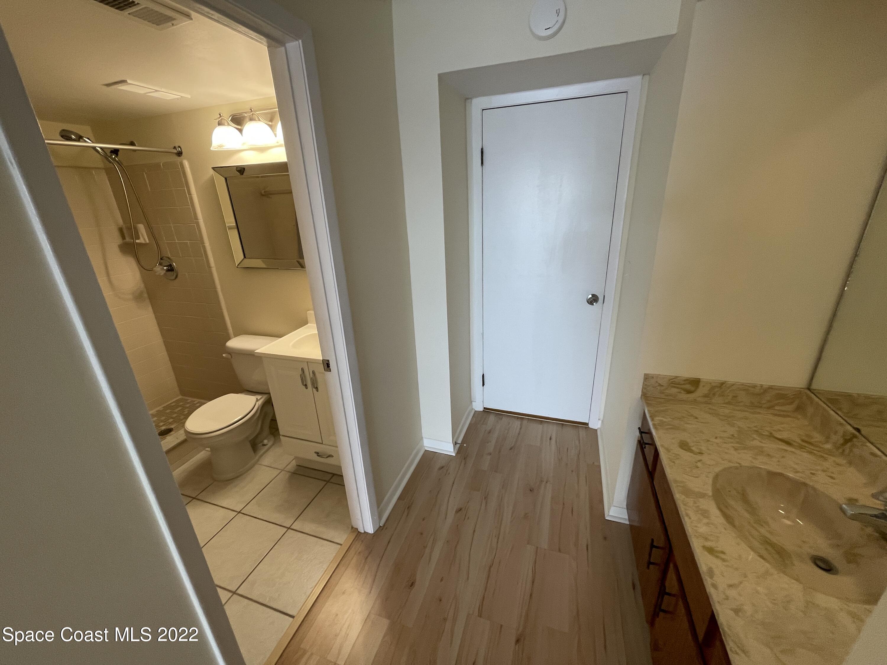 3799 South Banana River Boulevard, Unit 817 Cocoa Beach, FL 32931 - Photo 19 of 26 a bathroom with a sink and mirror with toilet