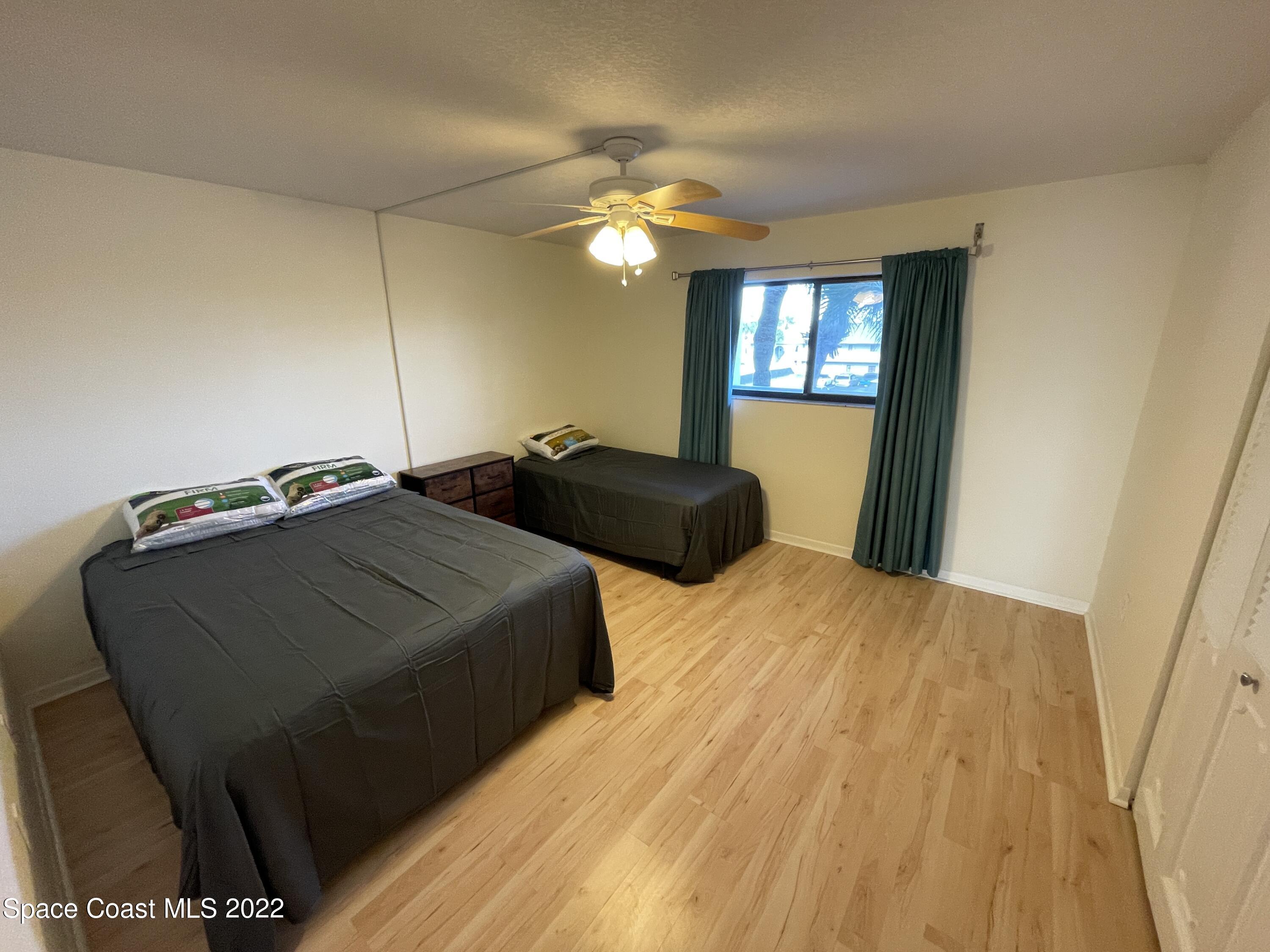 3799 South Banana River Boulevard, Unit 817 Cocoa Beach, FL 32931 - Photo 22 of 26 a bedroom with a bed and a chandelier