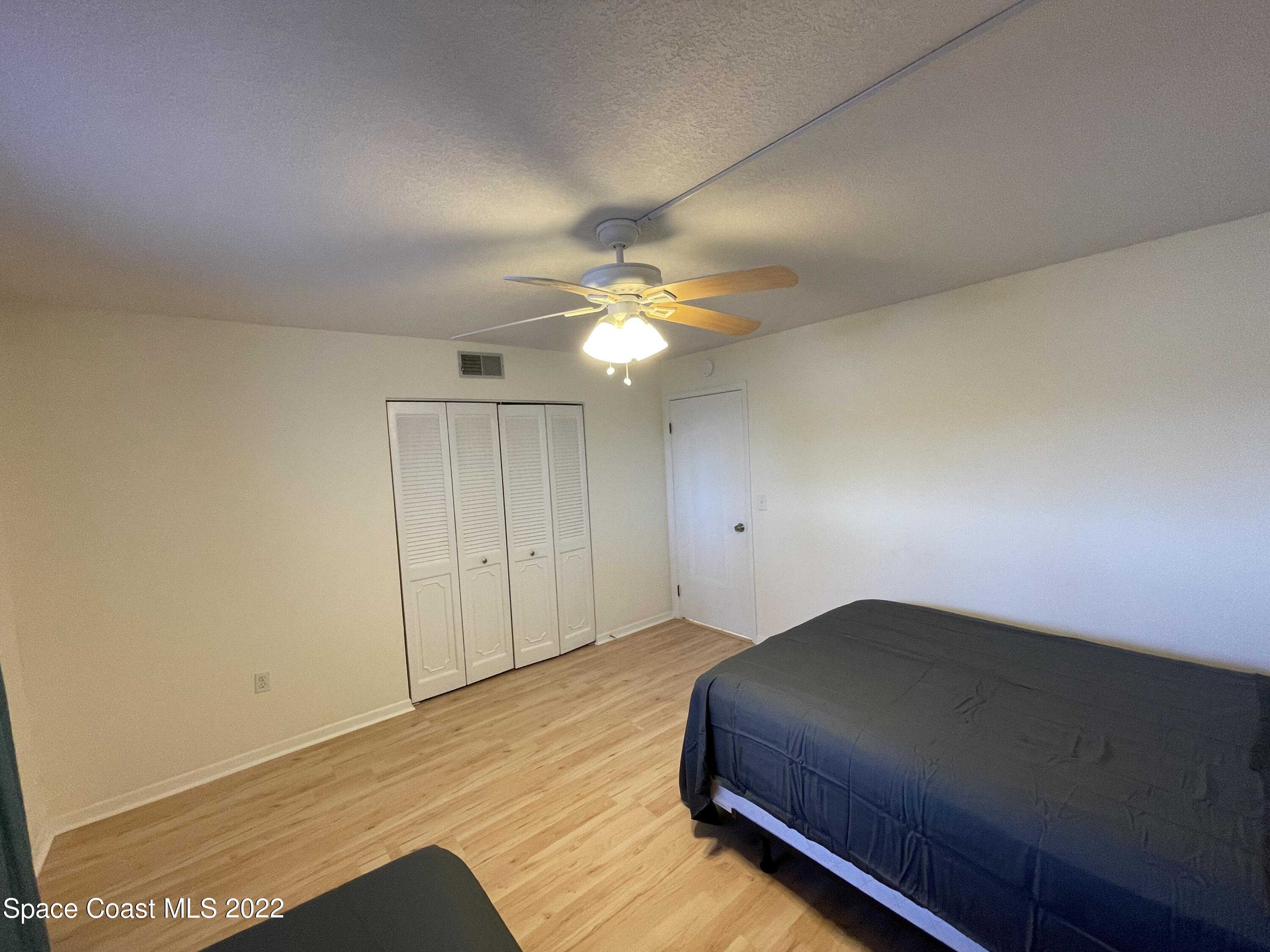 3799 South Banana River Boulevard, Unit 817 Cocoa Beach, FL 32931 - Photo 23 of 26 a bedroom with a bed and a ceiling fan