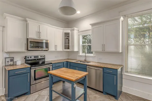 a kitchen with stainless steel appliances a refrigerator a stove a sink cabinets and a refrigerator