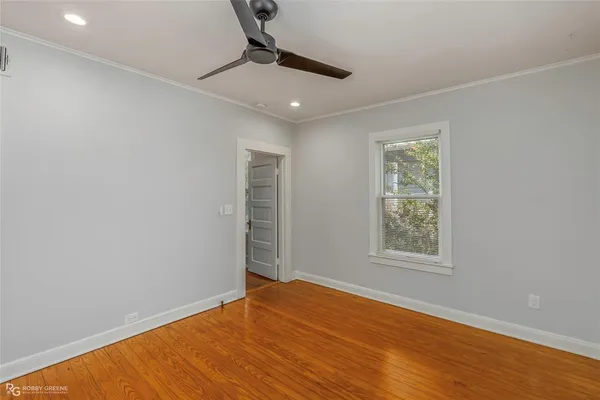 a view of an empty room with a window and wooden floor