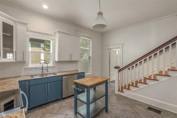 a kitchen with granite countertop stainless steel appliances a stove sink and microwave