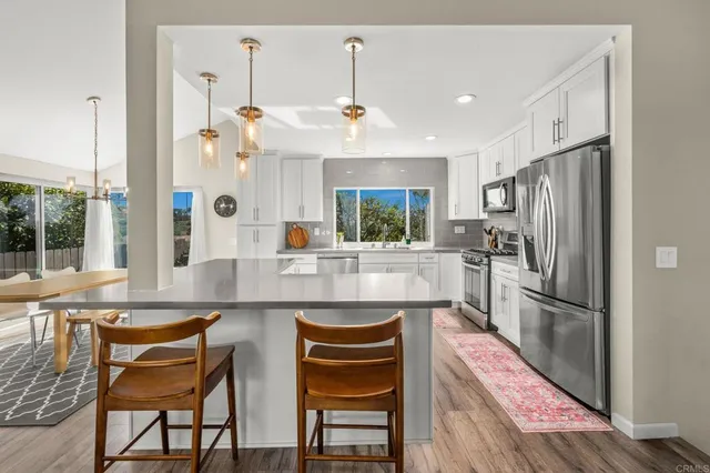 a kitchen with stainless steel appliances granite countertop a refrigerator and a stove top oven