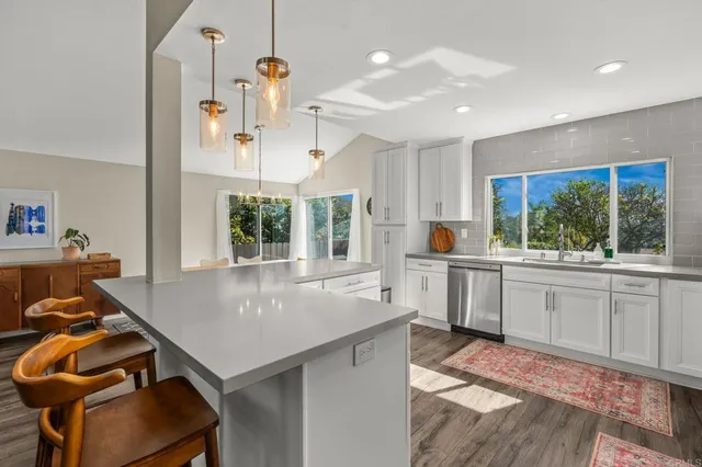 a kitchen with a stove a refrigerator and a dining table with wooden floor