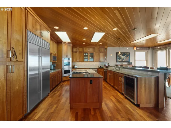 a kitchen with stainless steel appliances granite countertop a stove a sink dishwasher and a refrigerator