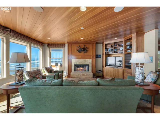 a living room with fireplace furniture and a large window