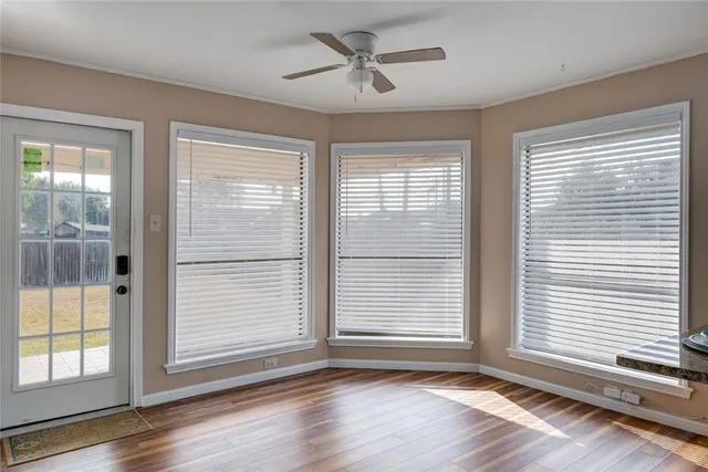 a view of a livingroom with a window and wooden floor