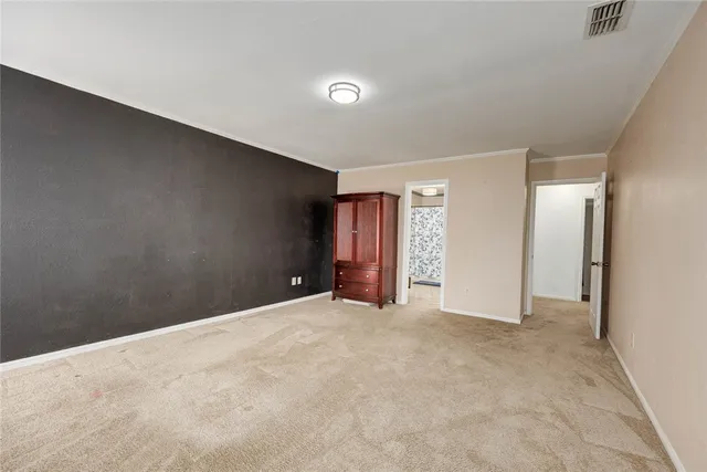 a view of an empty room with closet and entryway