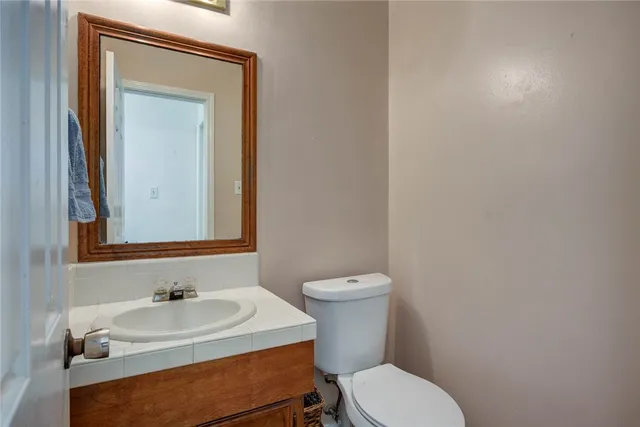 a bathroom with a sink a toilet and mirror