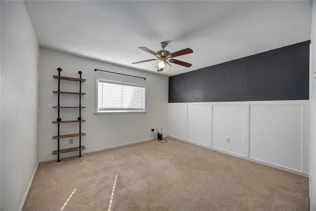 an empty room with windows and ceiling fan