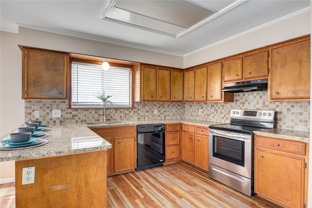 4737 Spring Fork Drive Corpus Christi, TX 78413 - Photo 8 of 37 a kitchen with stainless steel appliances granite countertop wooden cabinets a stove top oven a sink and dishwasher with wooden floor