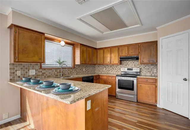 a kitchen with stainless steel appliances granite countertop a sink stove cabinets and wooden floor