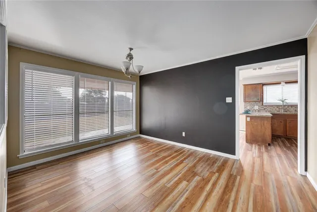 a view of a room with wooden floor and a kitchen