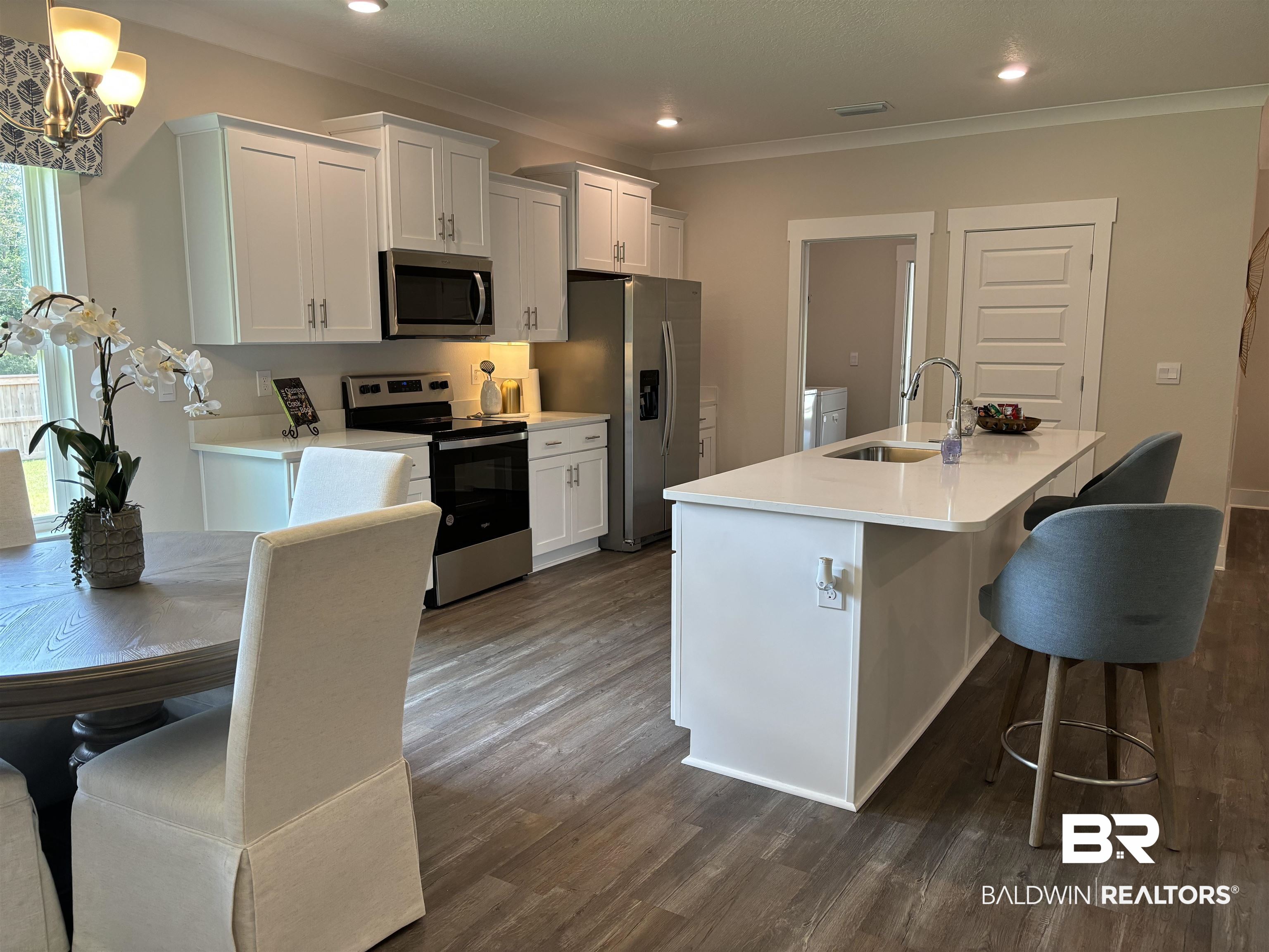 370 Barndling Street Fairhope, AL 36532 - Photo 14 of 30 Kitchen with sink, dark hardwood / wood-style flooring, crown molding, stainless steel appliances, and a center island with sink