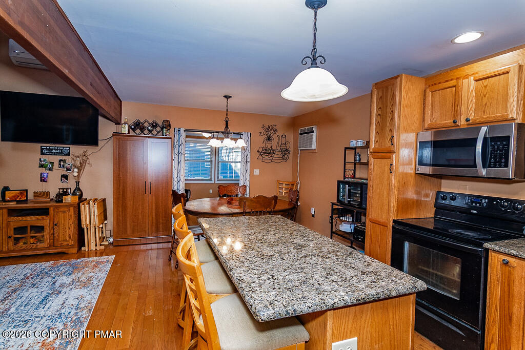 122 Dover Drive Bushkill, PA 18324 - Photo 16 of 45 a kitchen with stainless steel appliances granite countertop a stove a refrigerator a oven a sink with the island and wooden floor