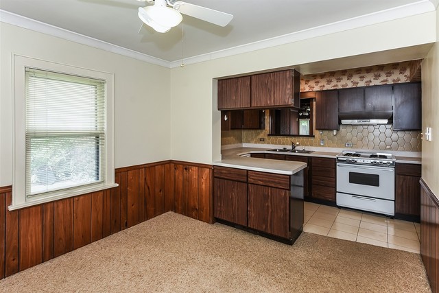 333 South Wolf Road Des Plaines, IL 60016 - Photo 11 of 25 a kitchen with a stove a sink and a microwave