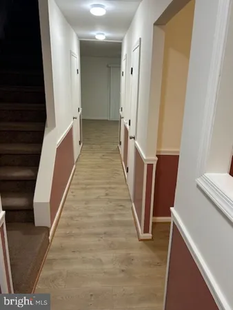 a view of a hallway with wooden floor and staircase