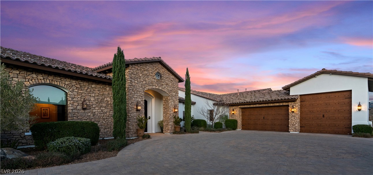1123 Christian Road Henderson, NV 89002 - Photo 65 of 94 Stone facade and a paver driveway welcome you to this elegant residence under a colorful sky.