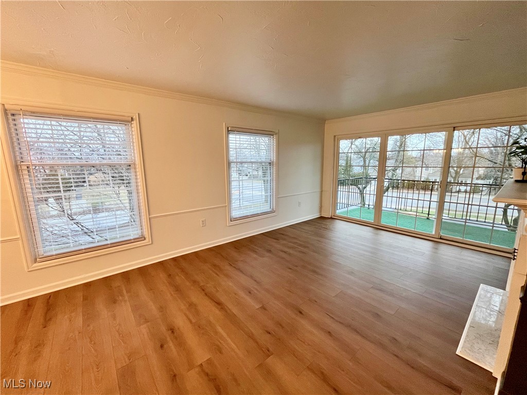 22701 Center Ridge Road, Unit 201 Rocky River, OH 44116 - Photo 15 of 37 Unfurnished room featuring wood-type flooring, ornamental molding, and a healthy amount of sunlight