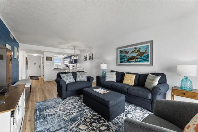 a living room with furniture a couch and paintings on the wall