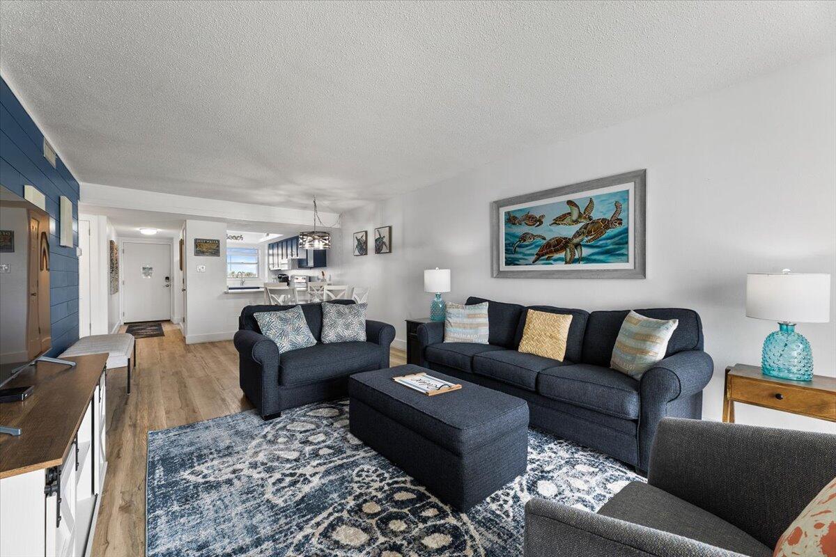 909 Santa Rosa Boulevard, Unit 138 Fort Walton Beach, FL 32548 - Photo 6 of 32 a living room with furniture a couch and paintings on the wall