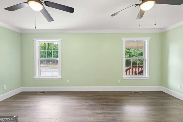 a view of a room with wooden floor fan and window