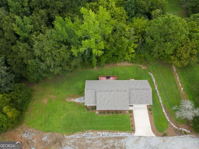 an aerial view of a house with swimming pool and a yard