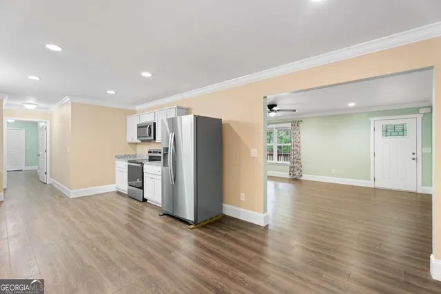 a view of a kitchen with refrigerator stove and wooden floor