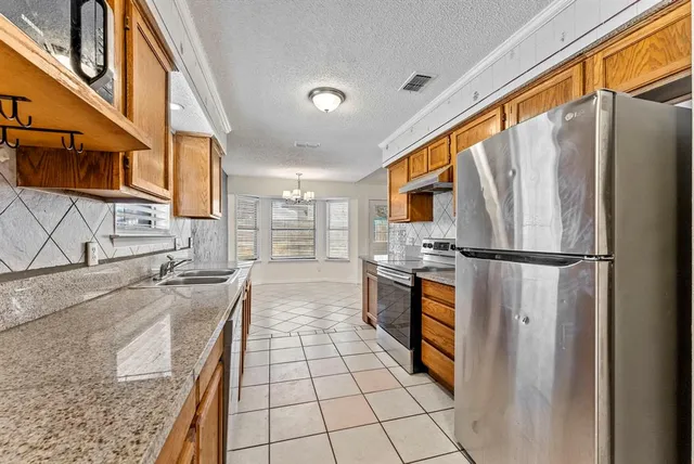 a kitchen with stainless steel appliances granite countertop a refrigerator and a sink