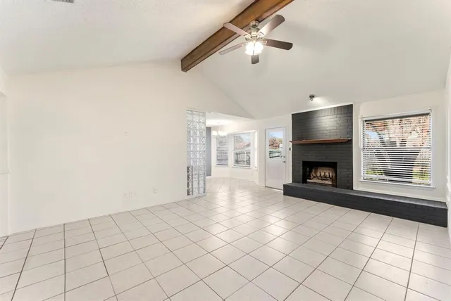 a view of an empty room with a fireplace and a window