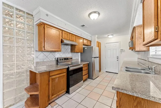 a kitchen with stainless steel appliances granite countertop a sink stove and refrigerator